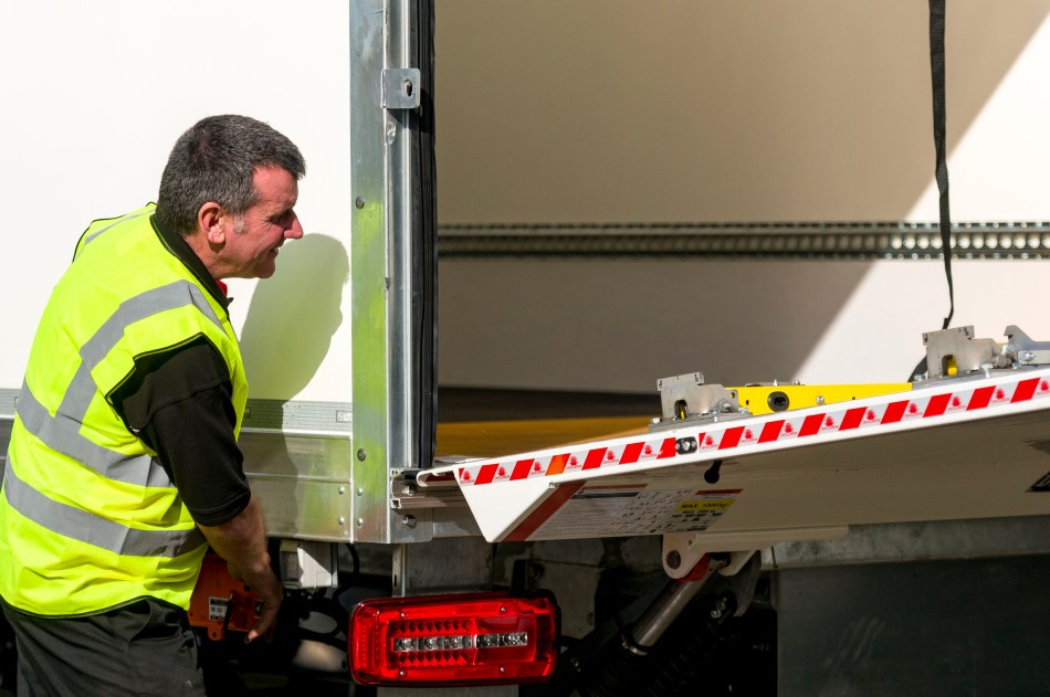 Engineer inspecting a commercial vehicle tail lift and its components
