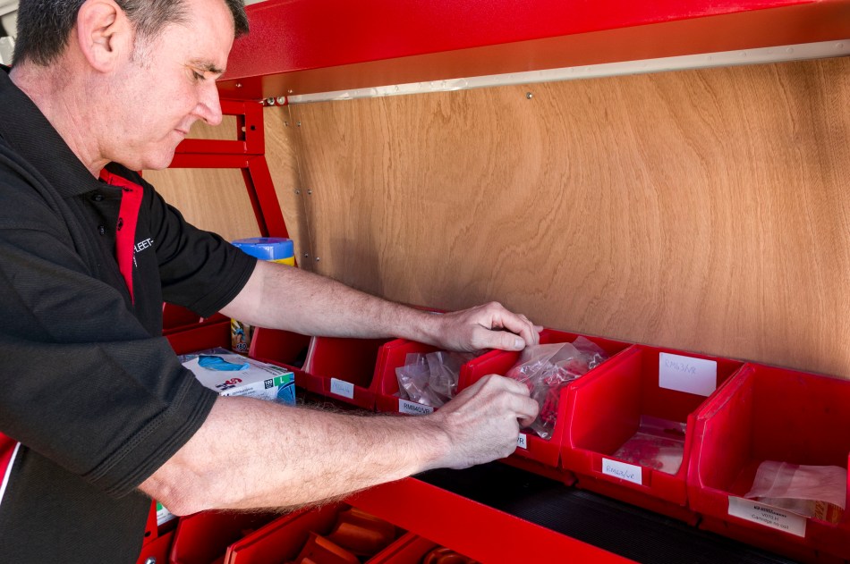 Engineer selecting parts from organised workshop stock bins