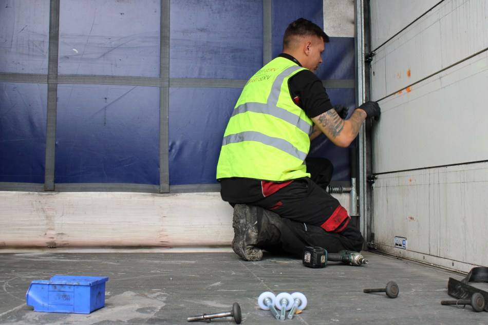 Engineer carrying out maintenance on a commercial vehicle shutter door