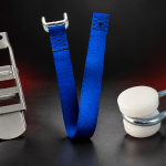 Curtainsider trailer components including a stainless steel overcentre buckle, blue bottom strap and bobbin roller with wire bracket